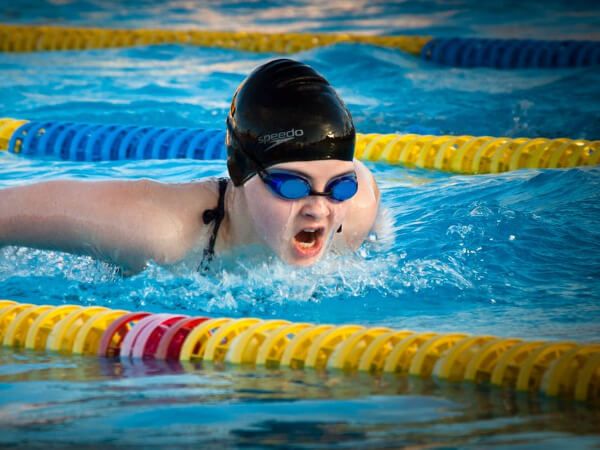 image of women wearing goggles swimming